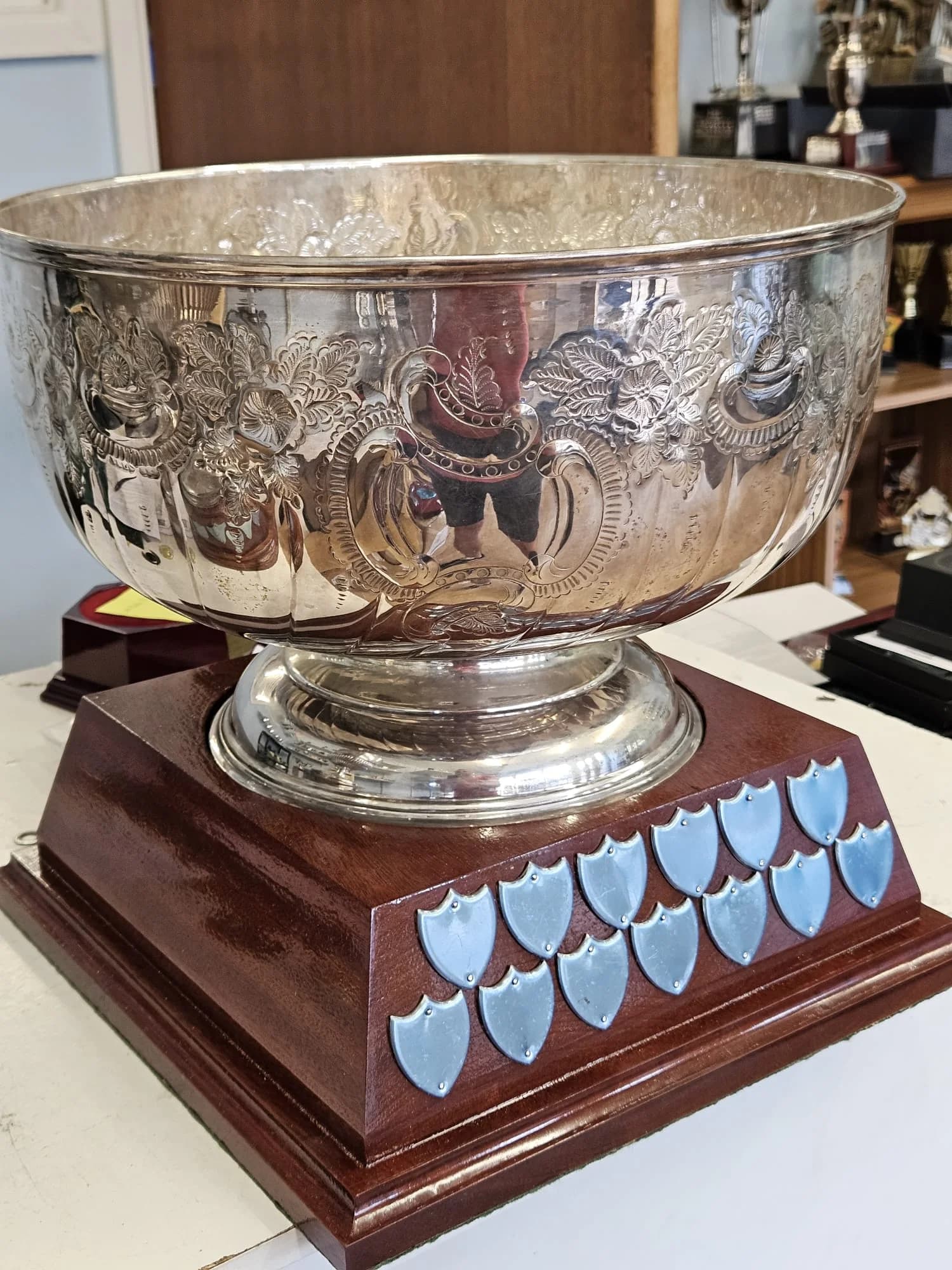 Ornate silver presentation bowl on a wooden perpetual award base